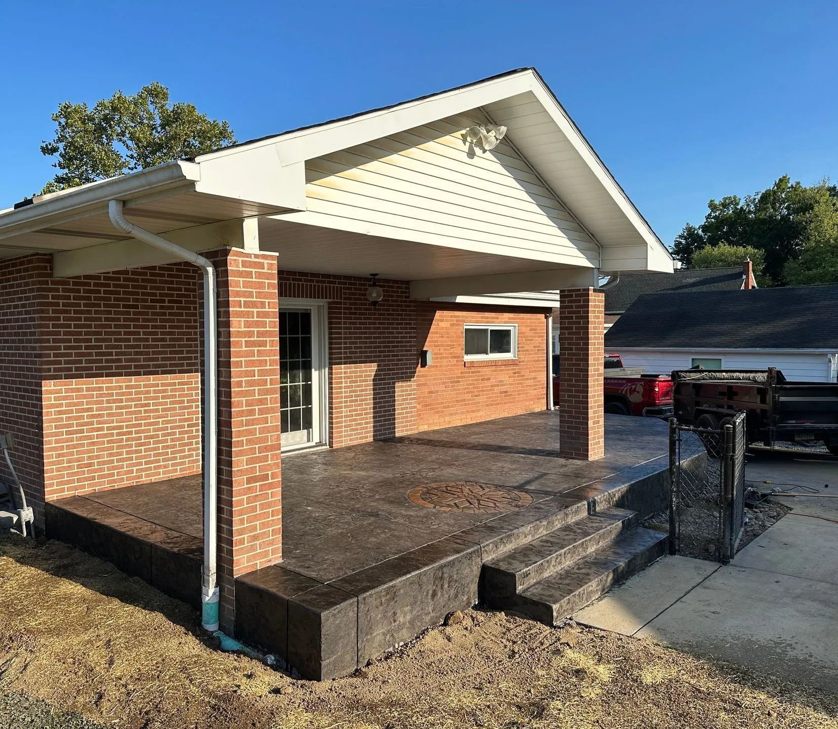 Brick house with a covered porch and concrete steps.
