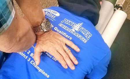 Chiropractor adjusting a person's back.