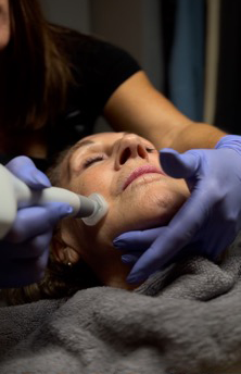 A woman is getting a facial treatment at a beauty salon.