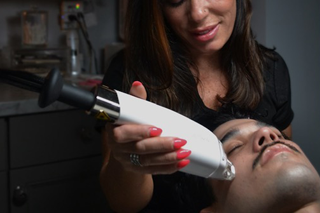 A woman with foundation on her face is looking down.