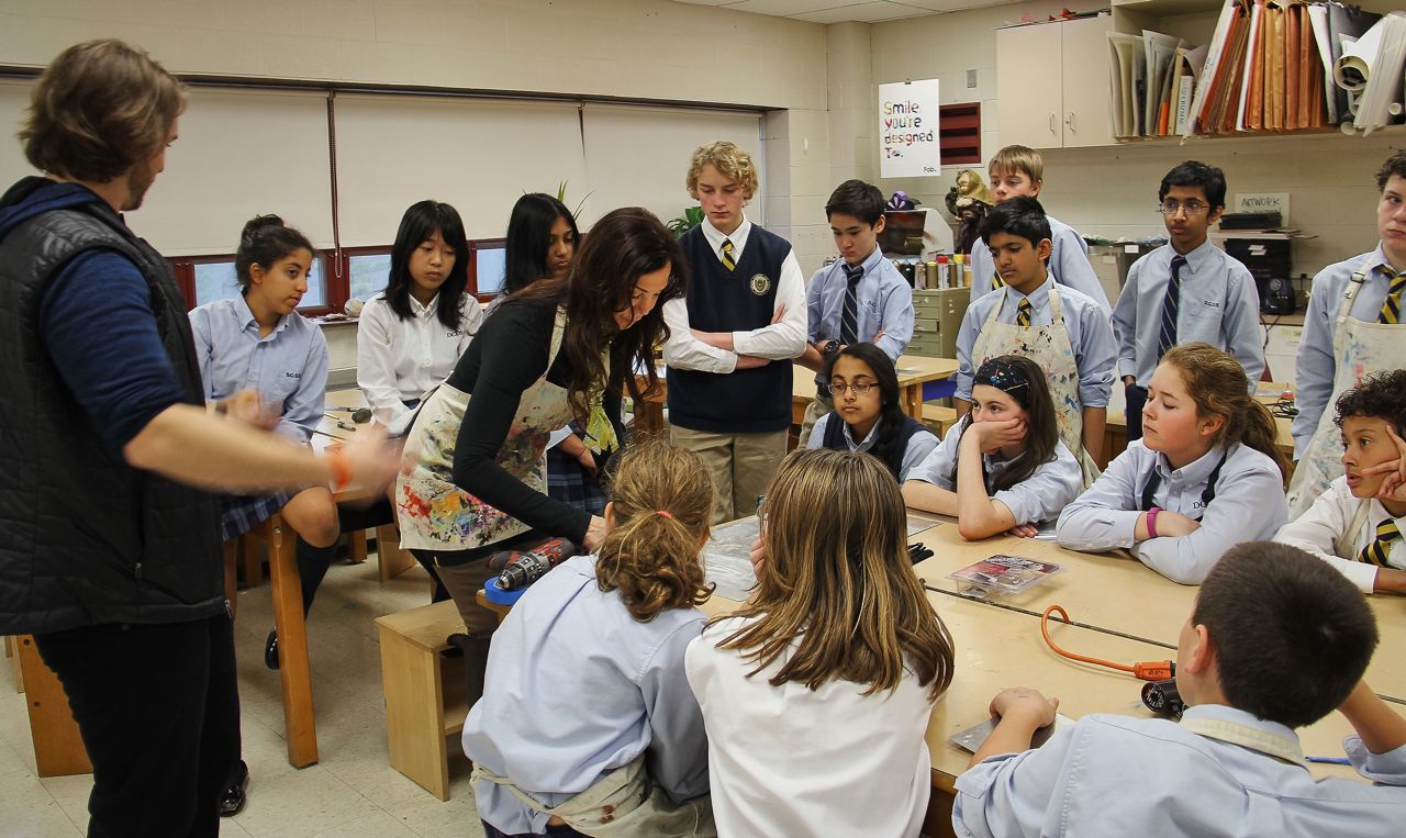 A group of children are sitting around a table in a classroom.
