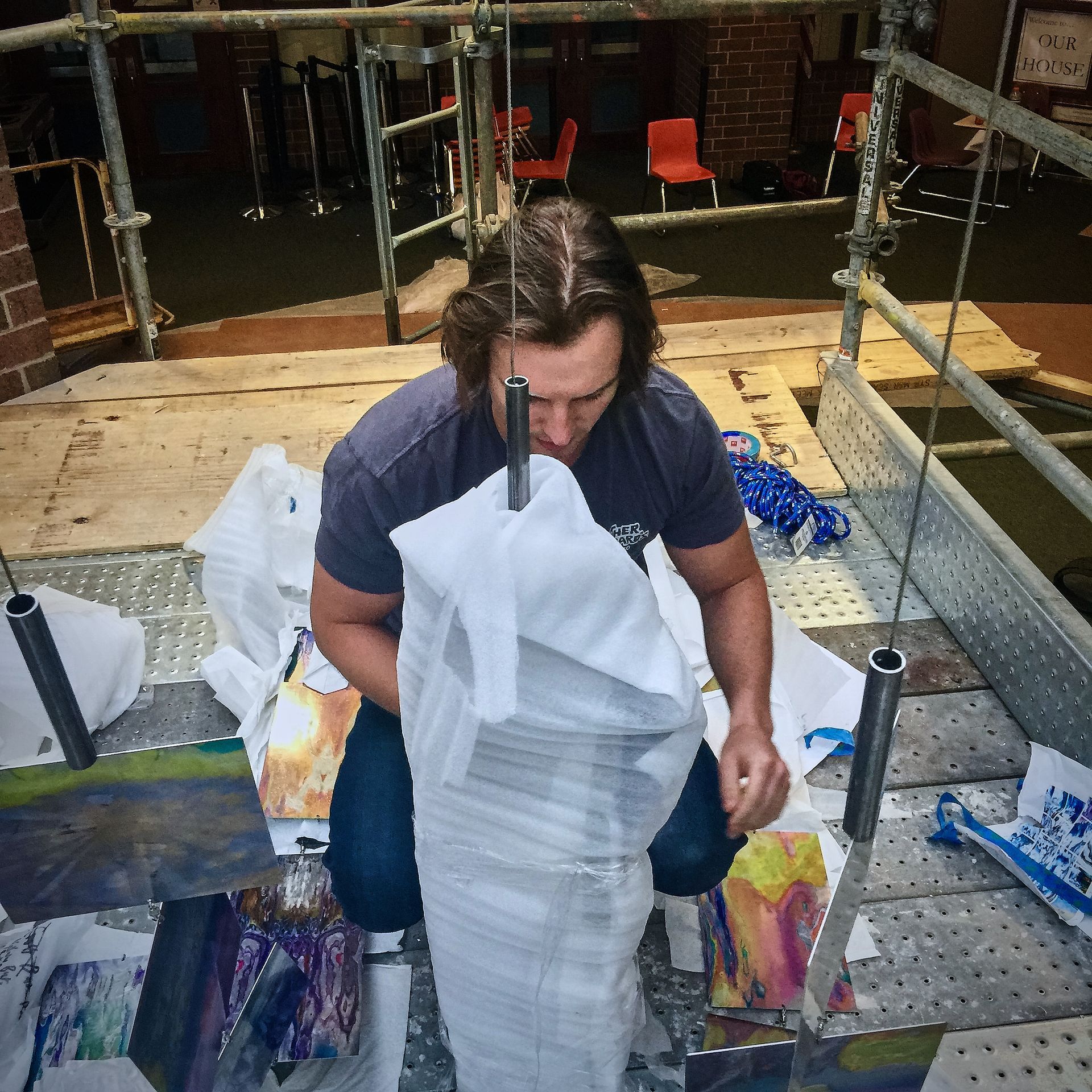 A man sitting on a scaffolding looking at a piece of paper
