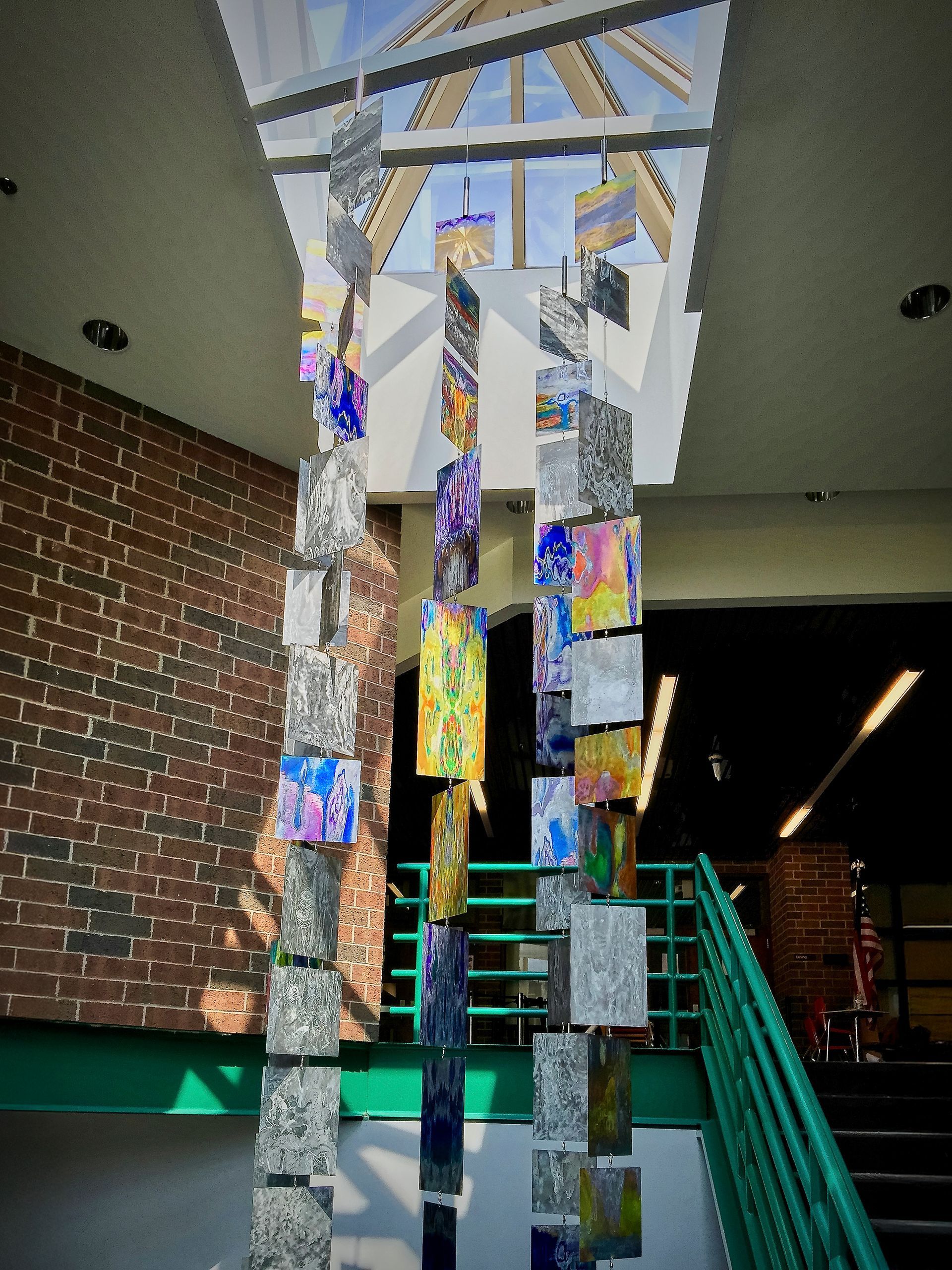 A colorful sculpture is hanging from the ceiling of a building