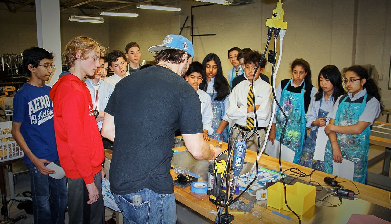 A group of people are standing around a table with a man wearing an aeropostale shirt