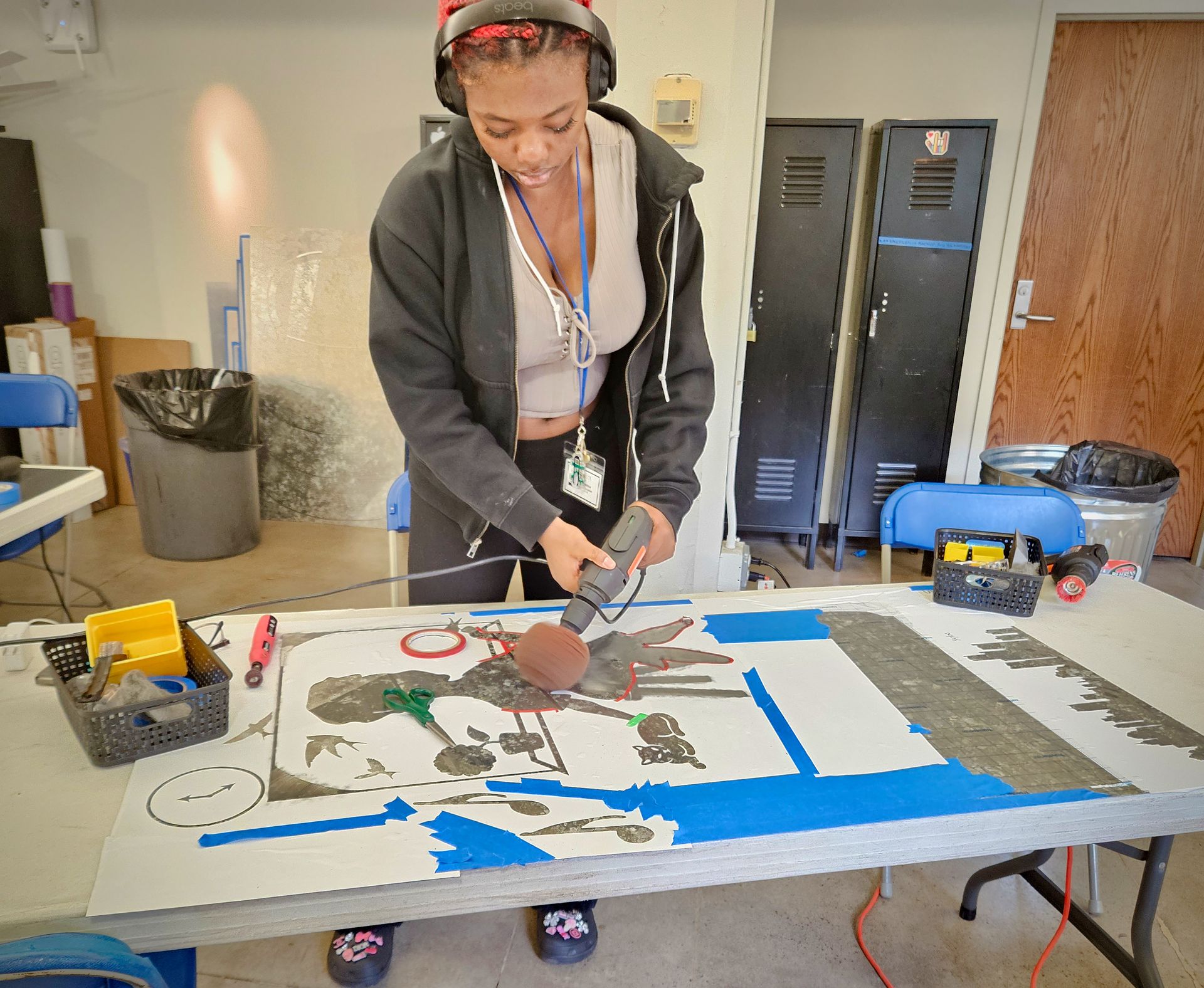 A woman is working on a painting on a table.
