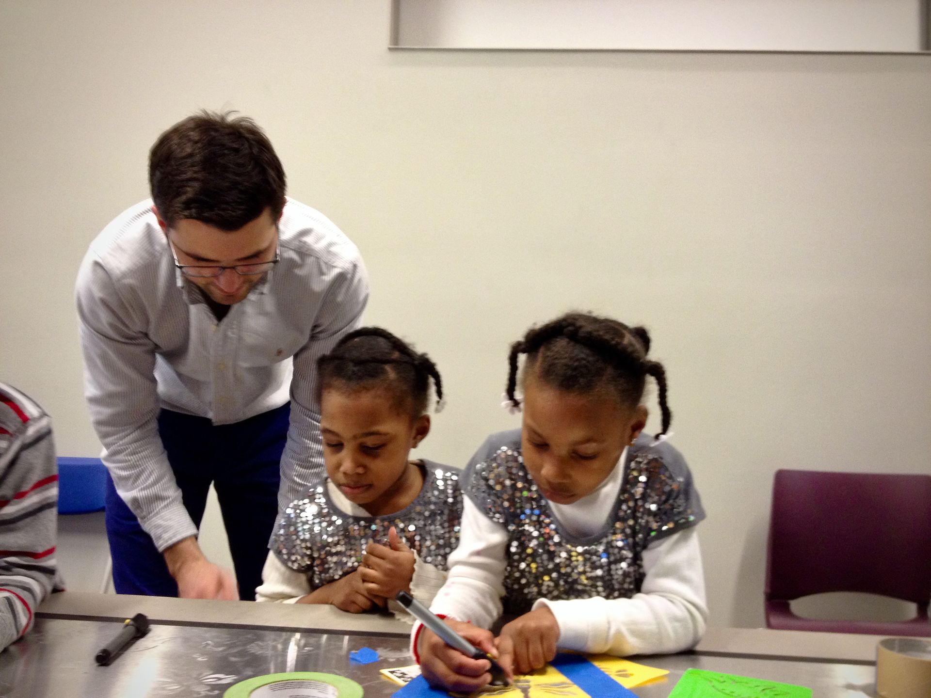 A man and two girls are sitting at a table