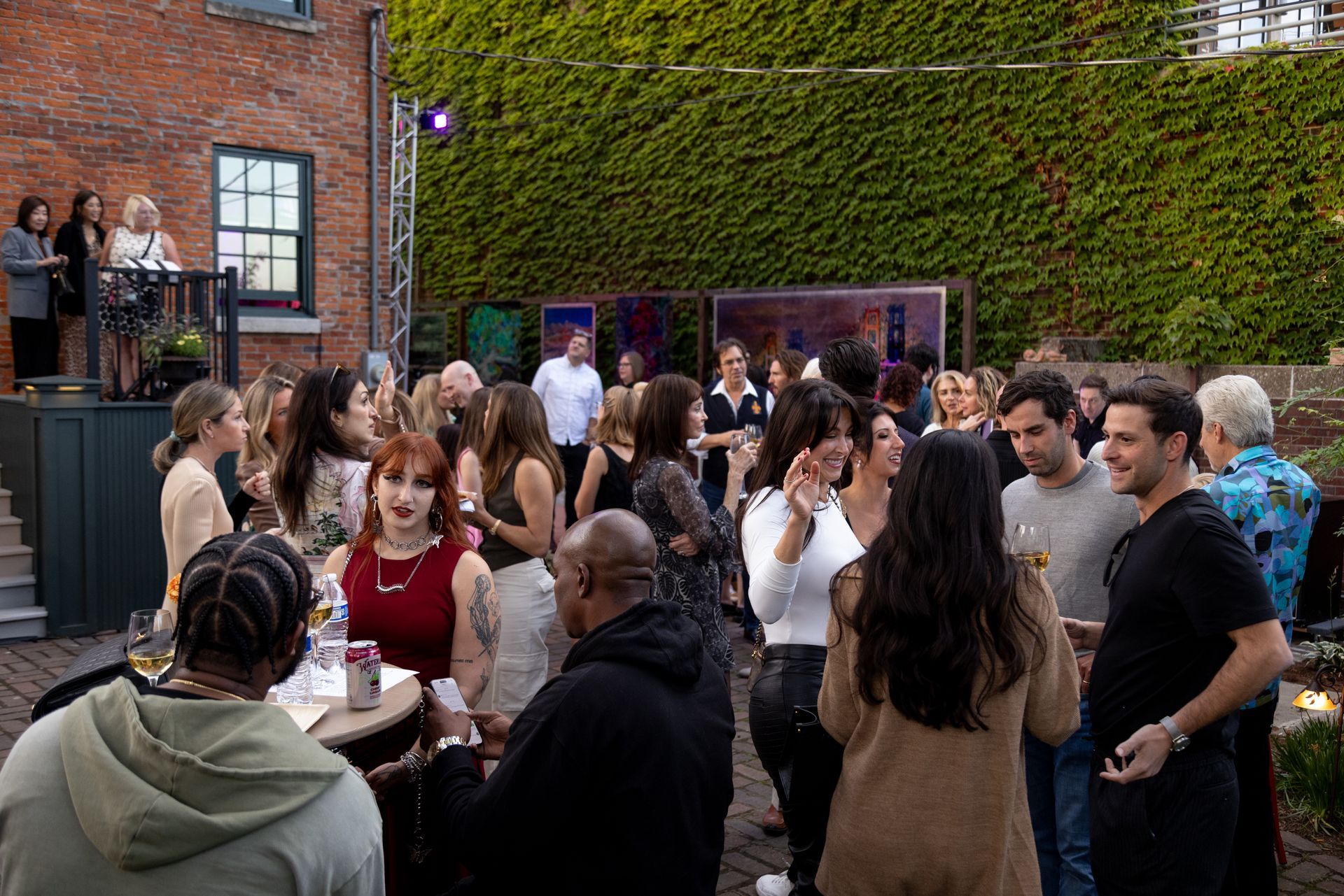 A large group of people are standing around a table at a party.