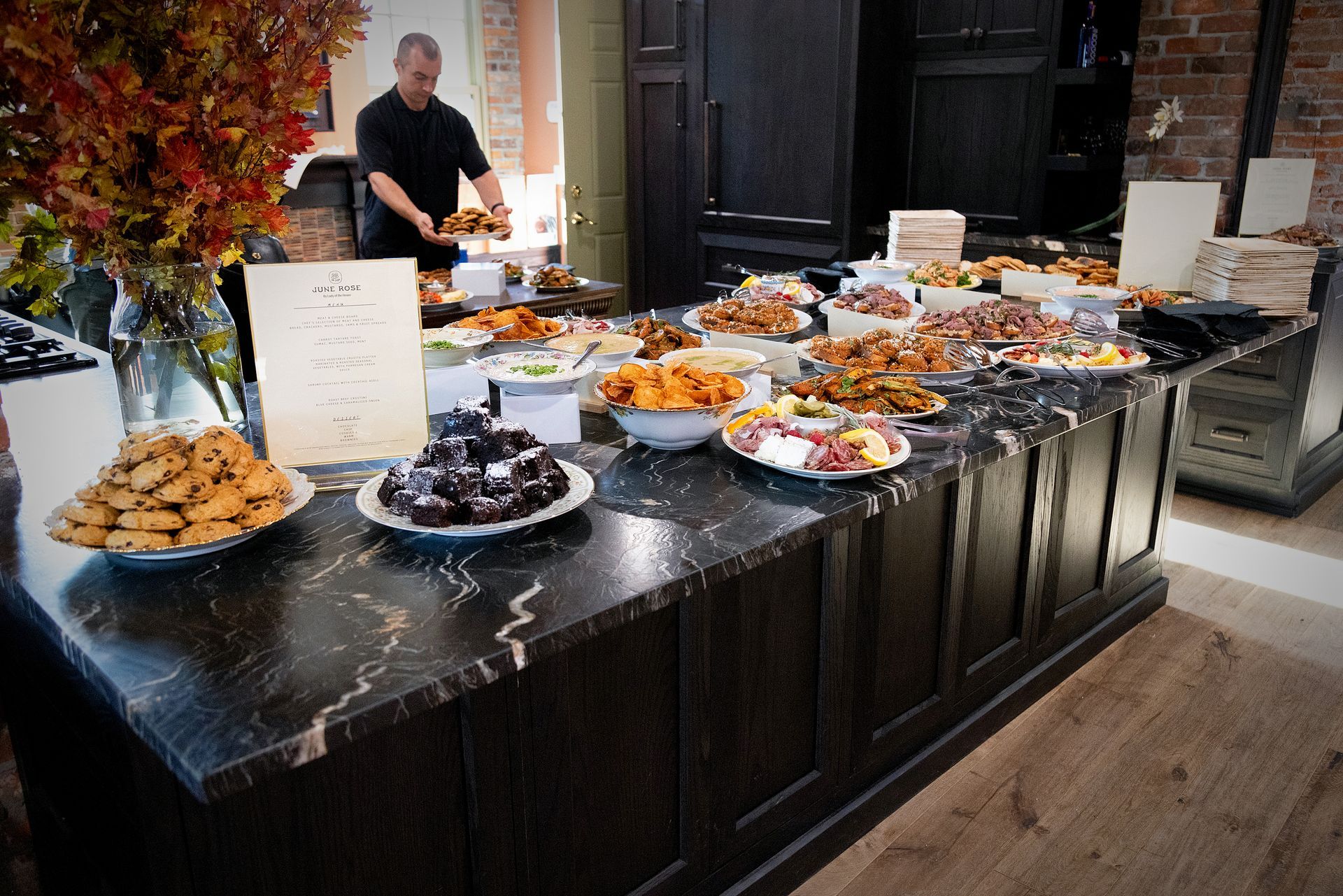 A buffet table with plates of food and a man standing behind it