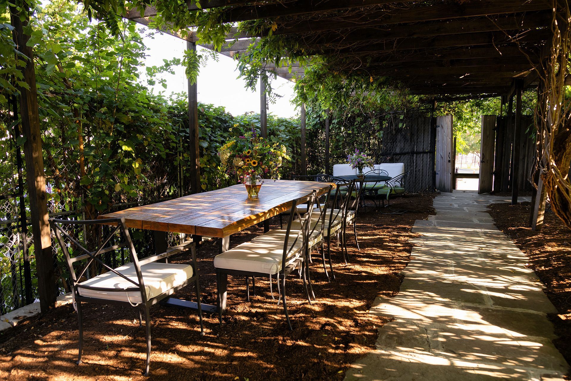 A patio with a table and chairs under a pergola