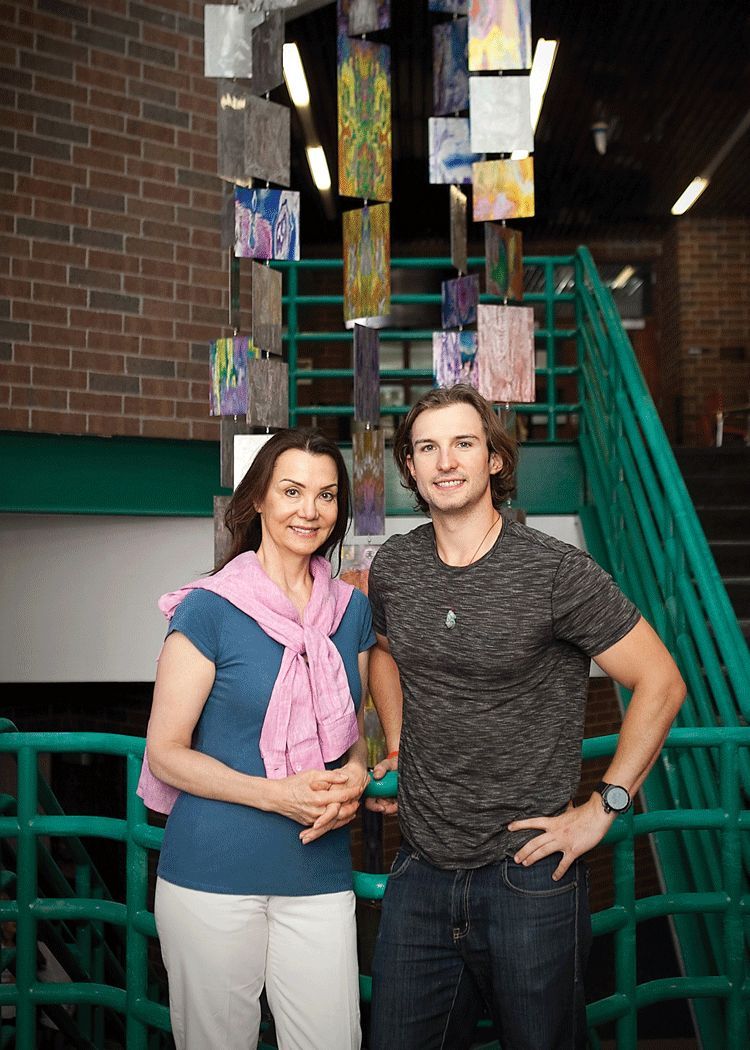 A man and a woman are standing next to each other in front of a staircase.
