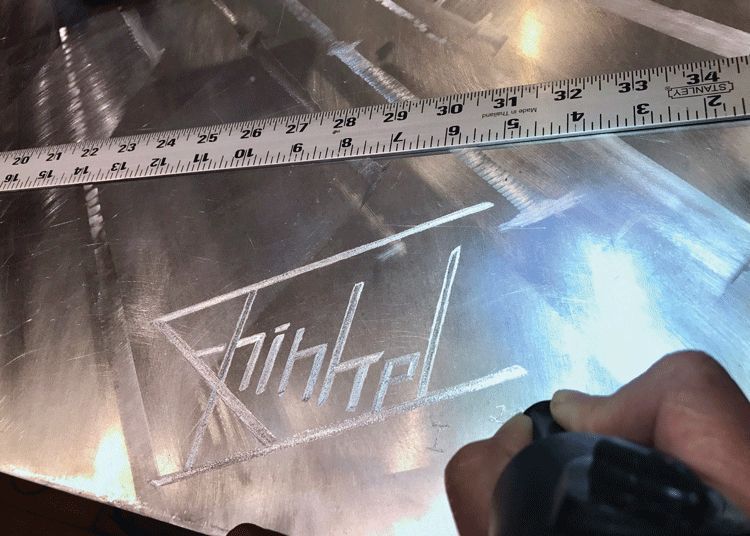 A person is measuring a piece of metal with a ruler