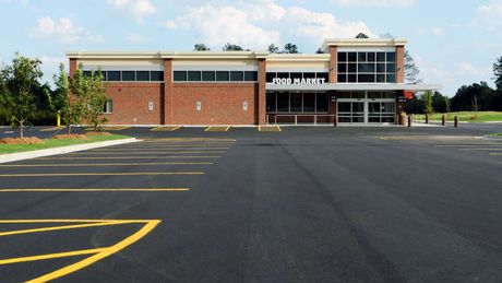 A car is parked in a parking lot with a yellow line