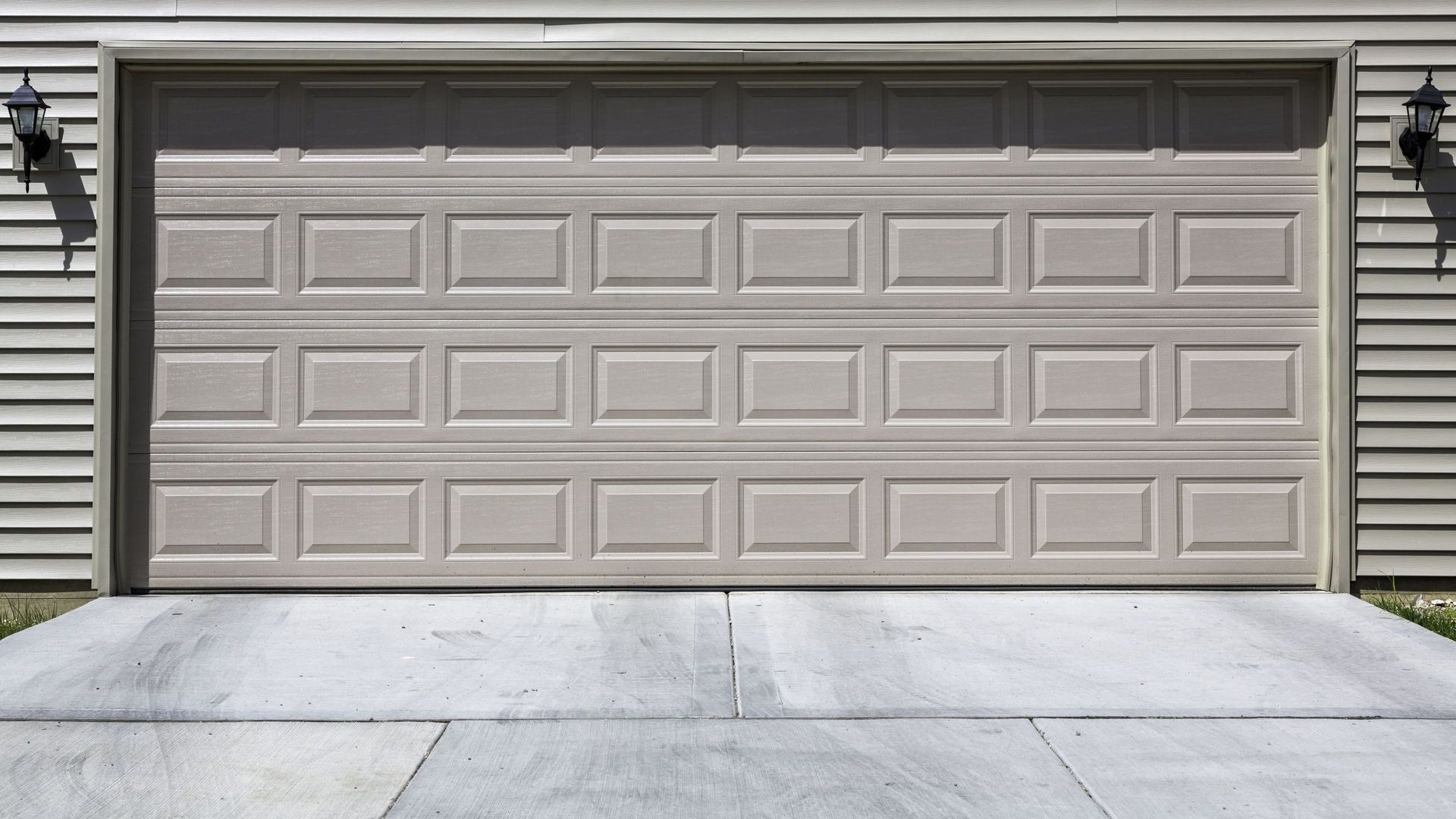 A concrete walkway is being built next to a garage door.