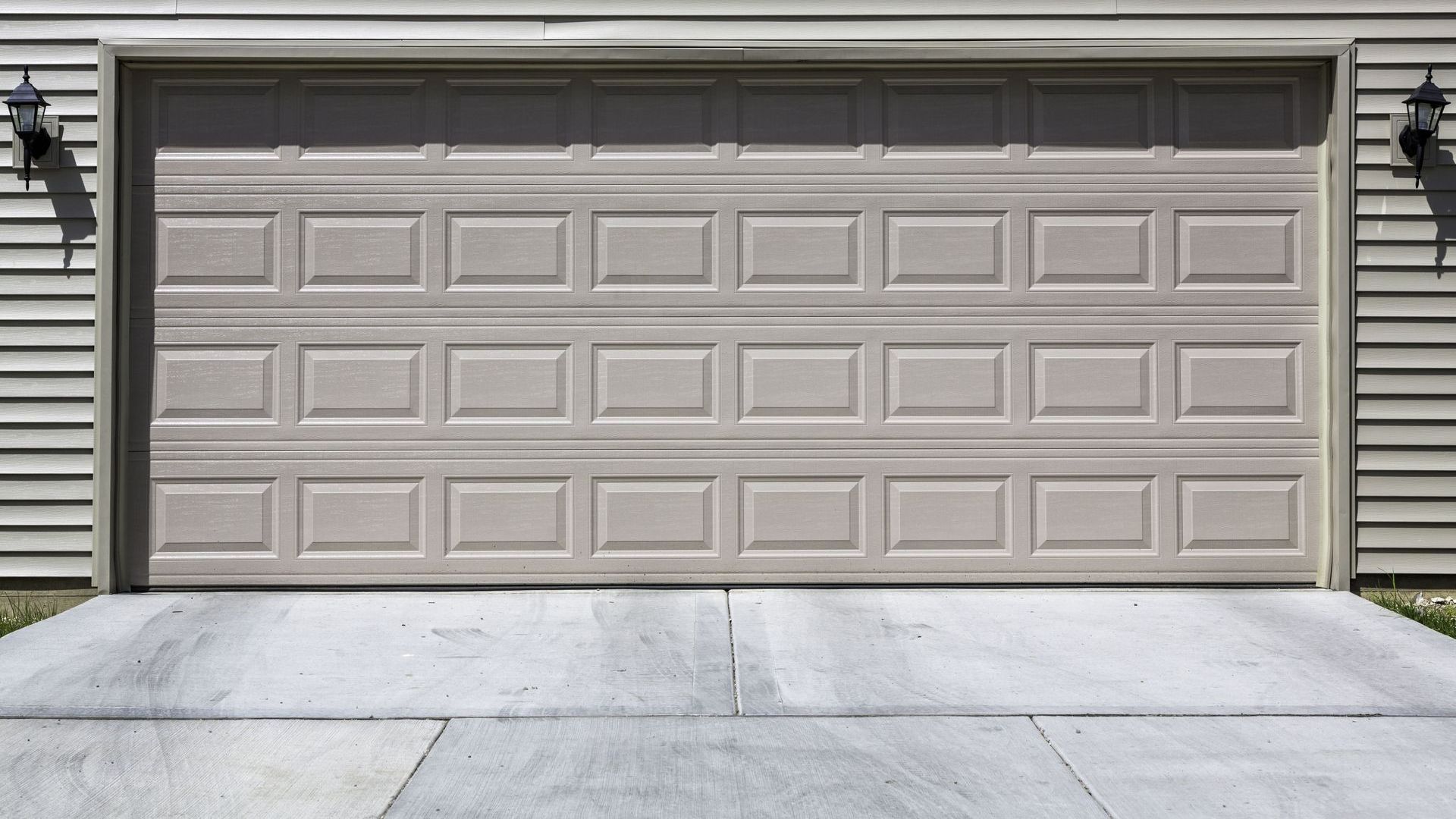 A concrete walkway is being built next to a garage door.