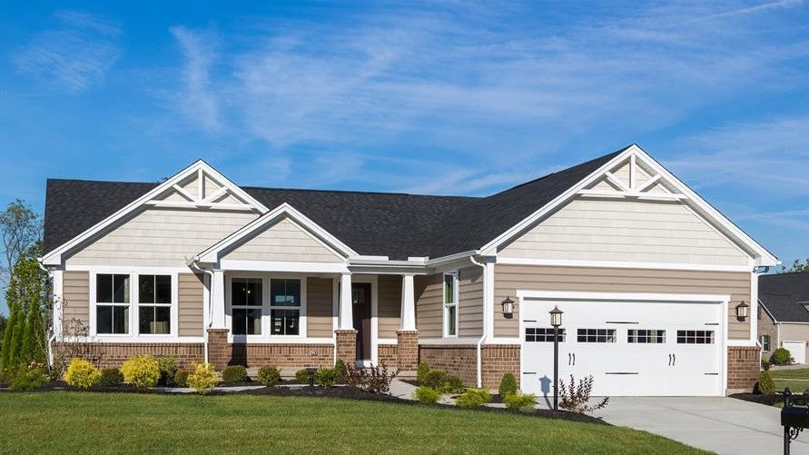 A large house with a large garage and a mailbox in front of it