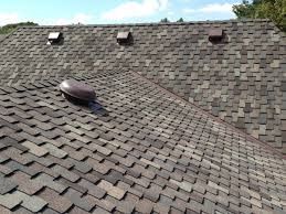 A close up of a roof with shingles and vents on it