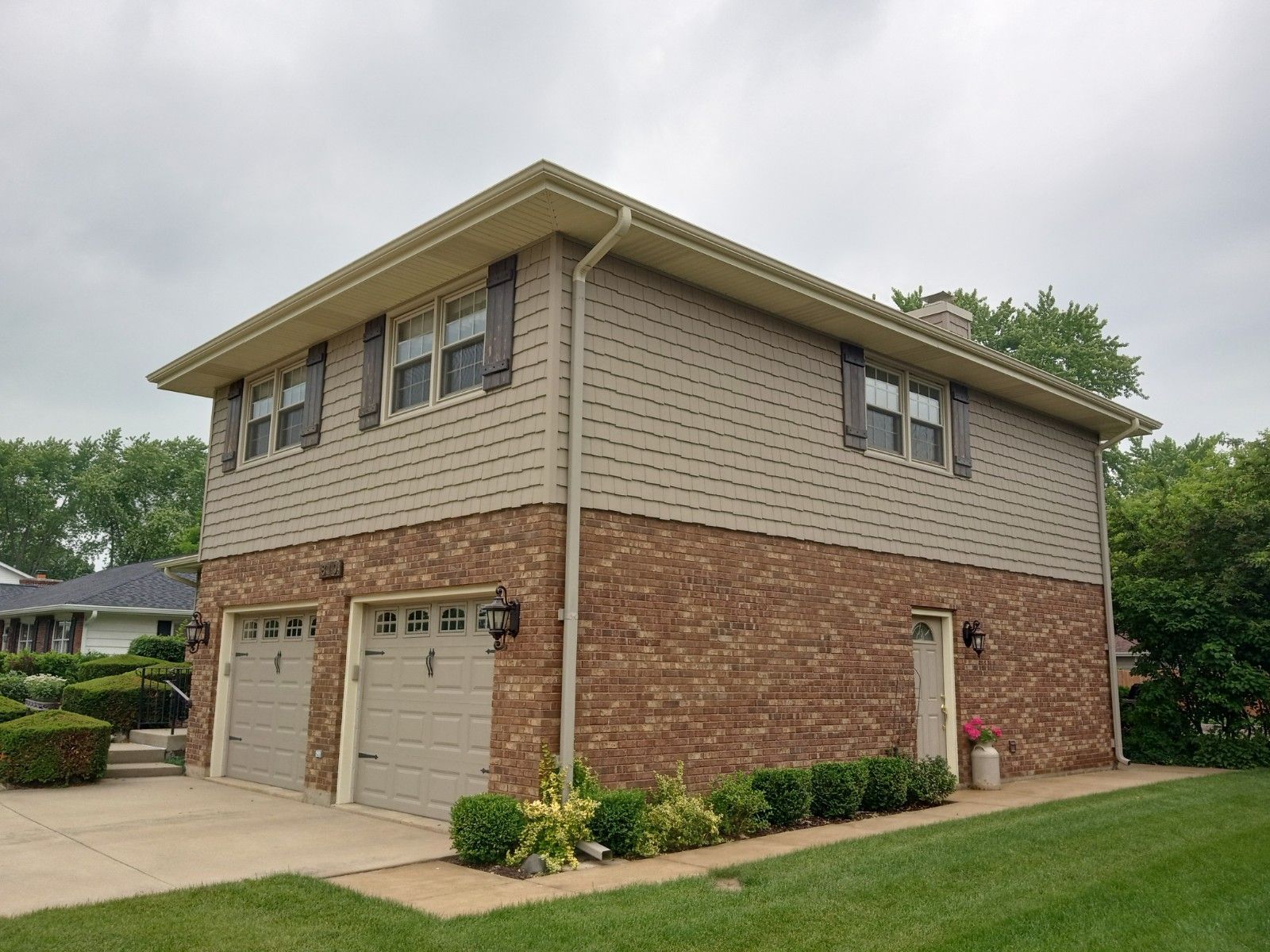A large brick house with a garage and two garage doors