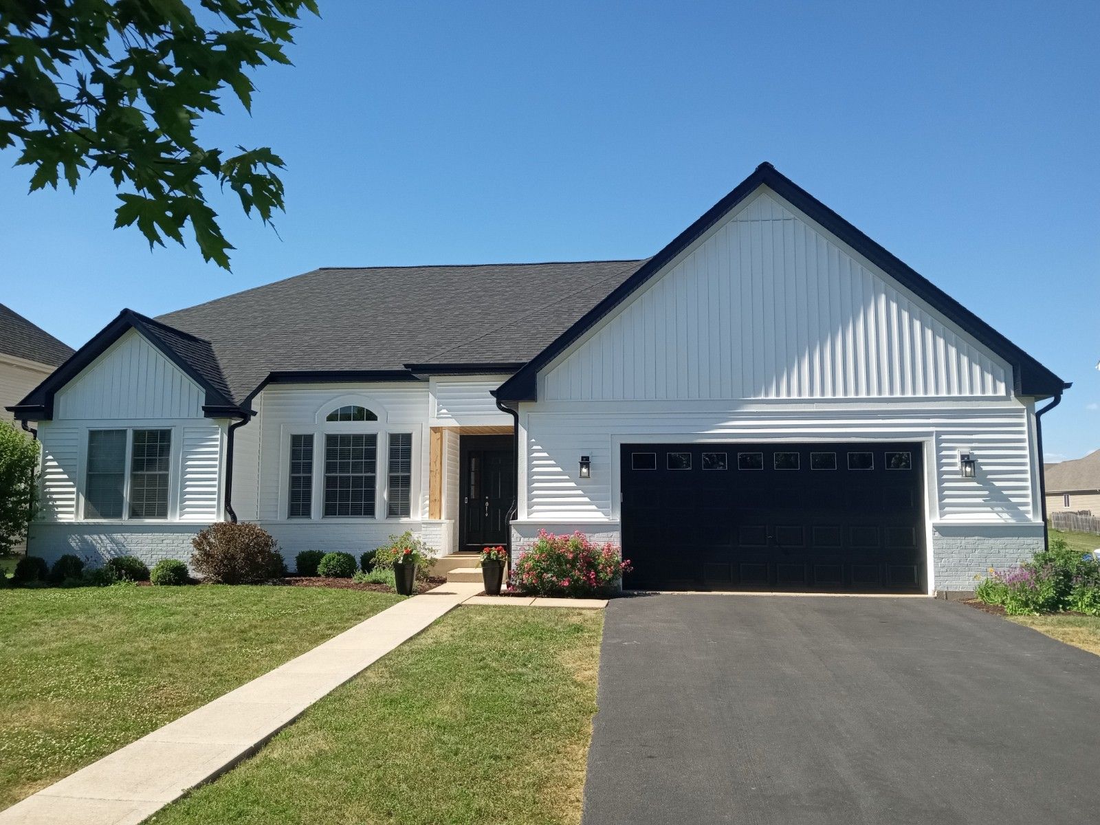 A white house with a black garage door