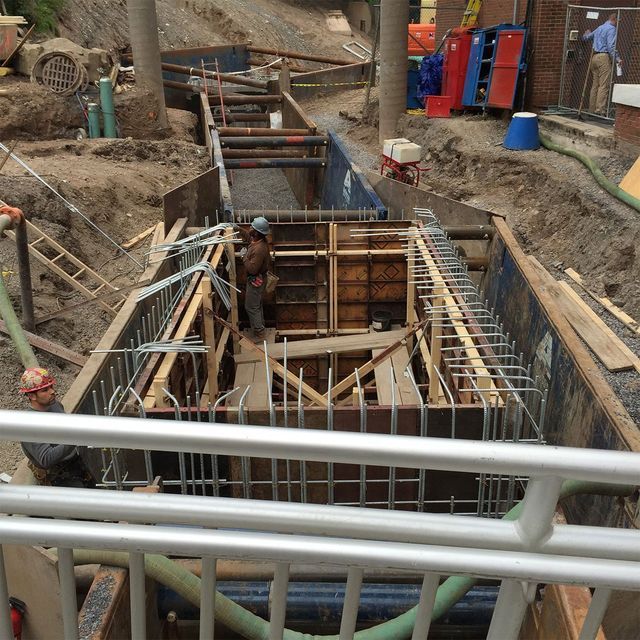 a man in a hard hat stands in the middle of a construction site