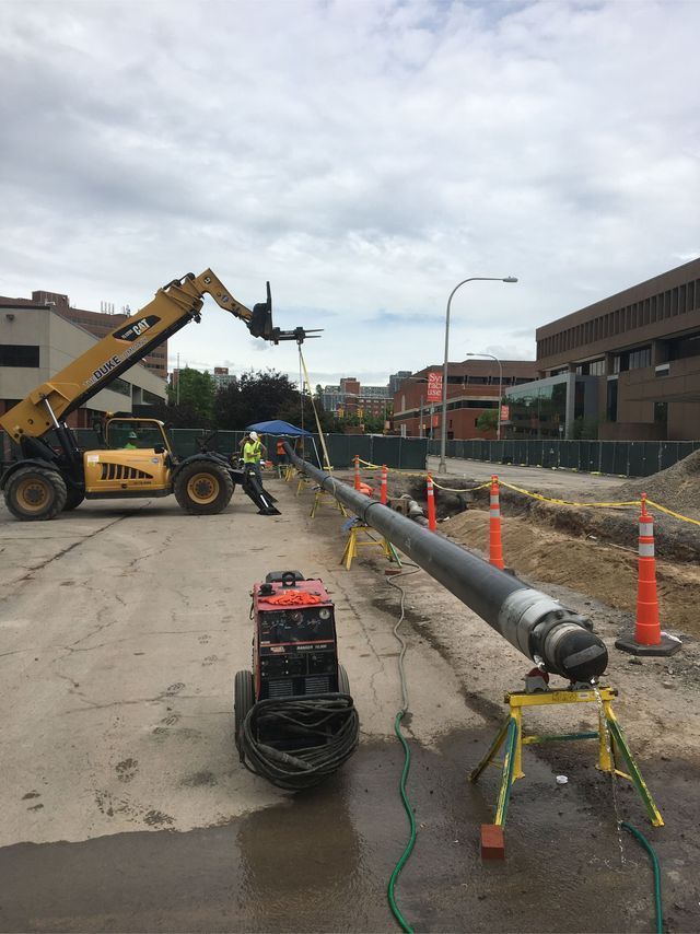 a man is working on a pipe in a construction site .