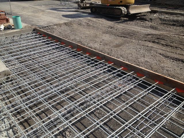 a construction site with a yellow excavator in the background
