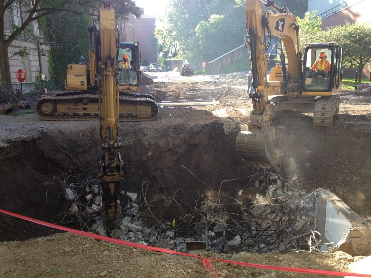 two bulldozers are digging a hole in the ground