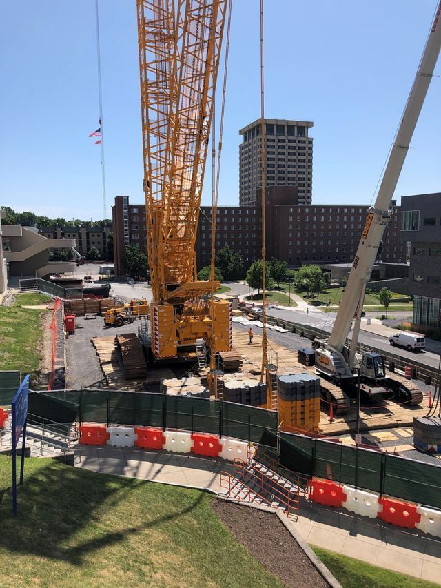 a large yellow crane is sitting on top of a construction site .