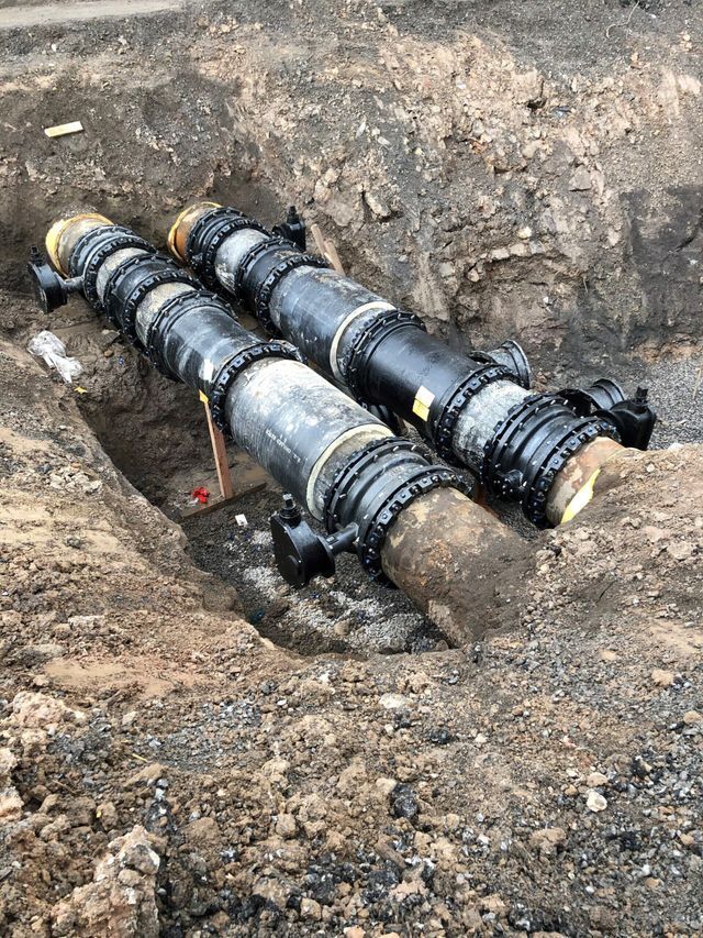 a couple of pipes are sitting in the dirt .