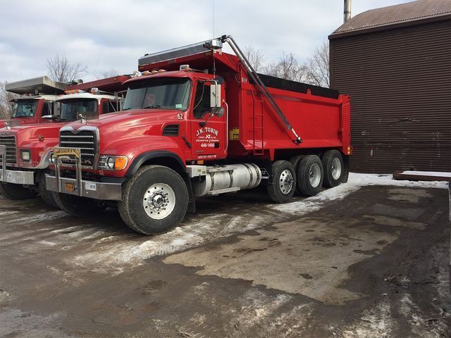two red dump trucks are parked next to each other