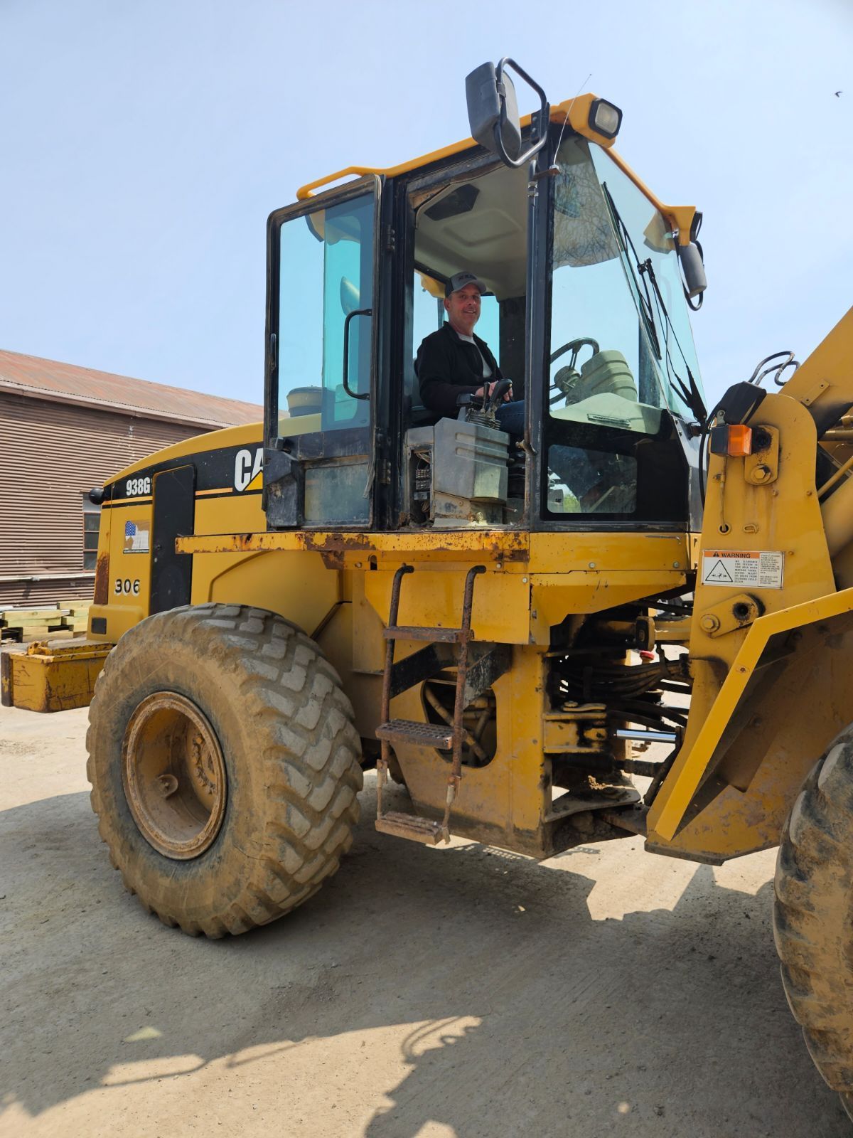 a man is driving a yellow cat wheel loader