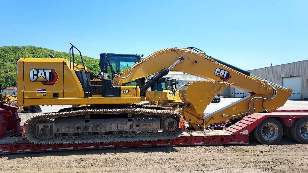 a large yellow excavator is sitting on top of a red trailer .