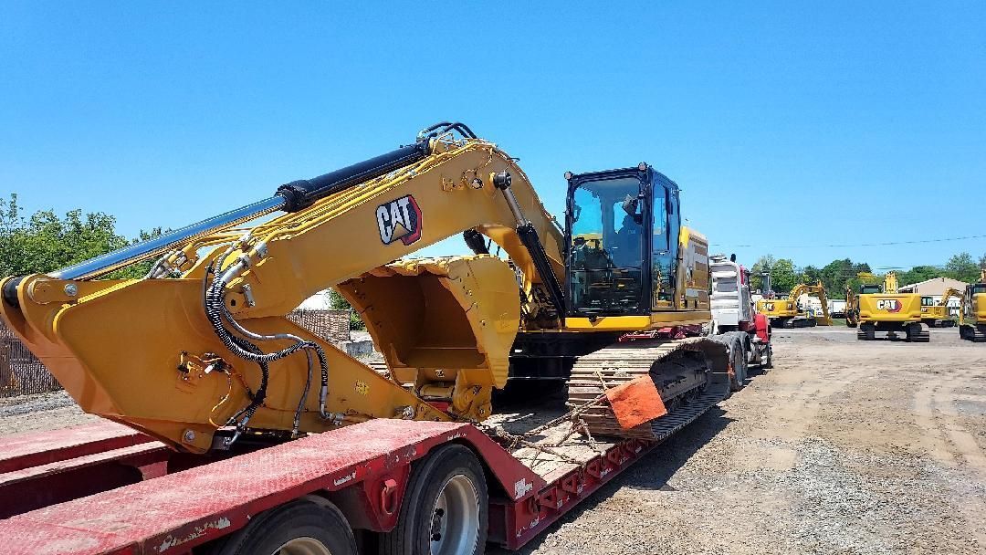 a large yellow excavator is sitting on top of a red trailer .