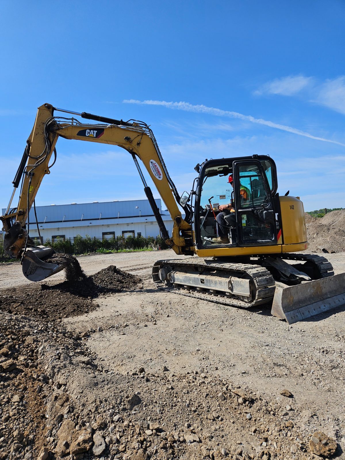 a yellow excavator is digging a hole in a dirt field .