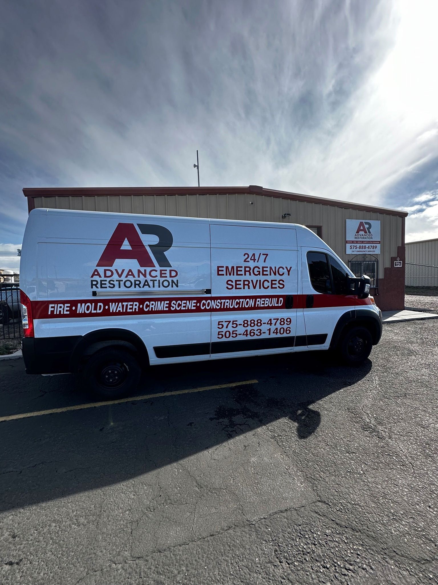 A white van is parked in front of a building.