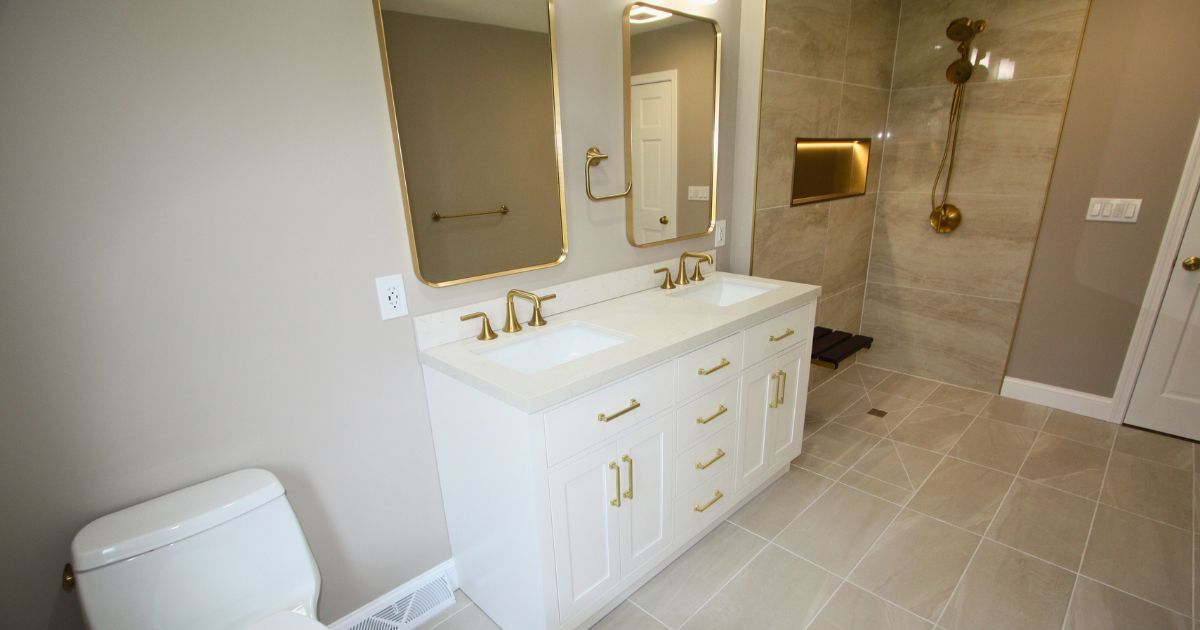 Spacious bathroom with white vanity, mirrors, beige tile floor, and tiled shower area