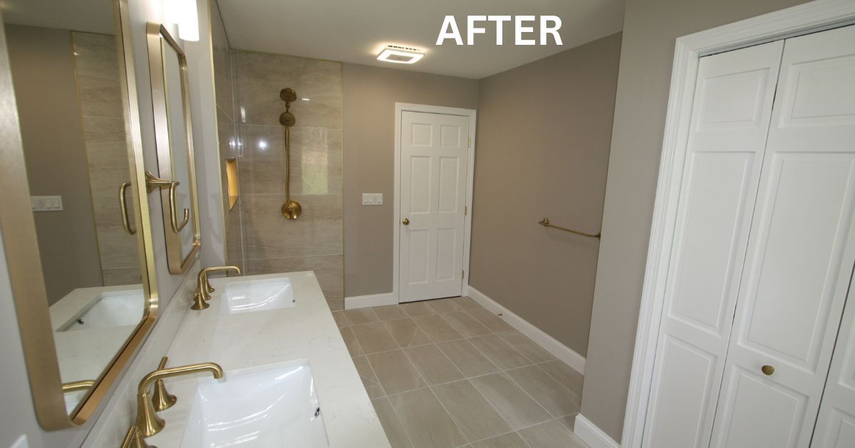 Bathroom after renovation with beige walls, white cabinets, gold fixtures, and a shower in the back.