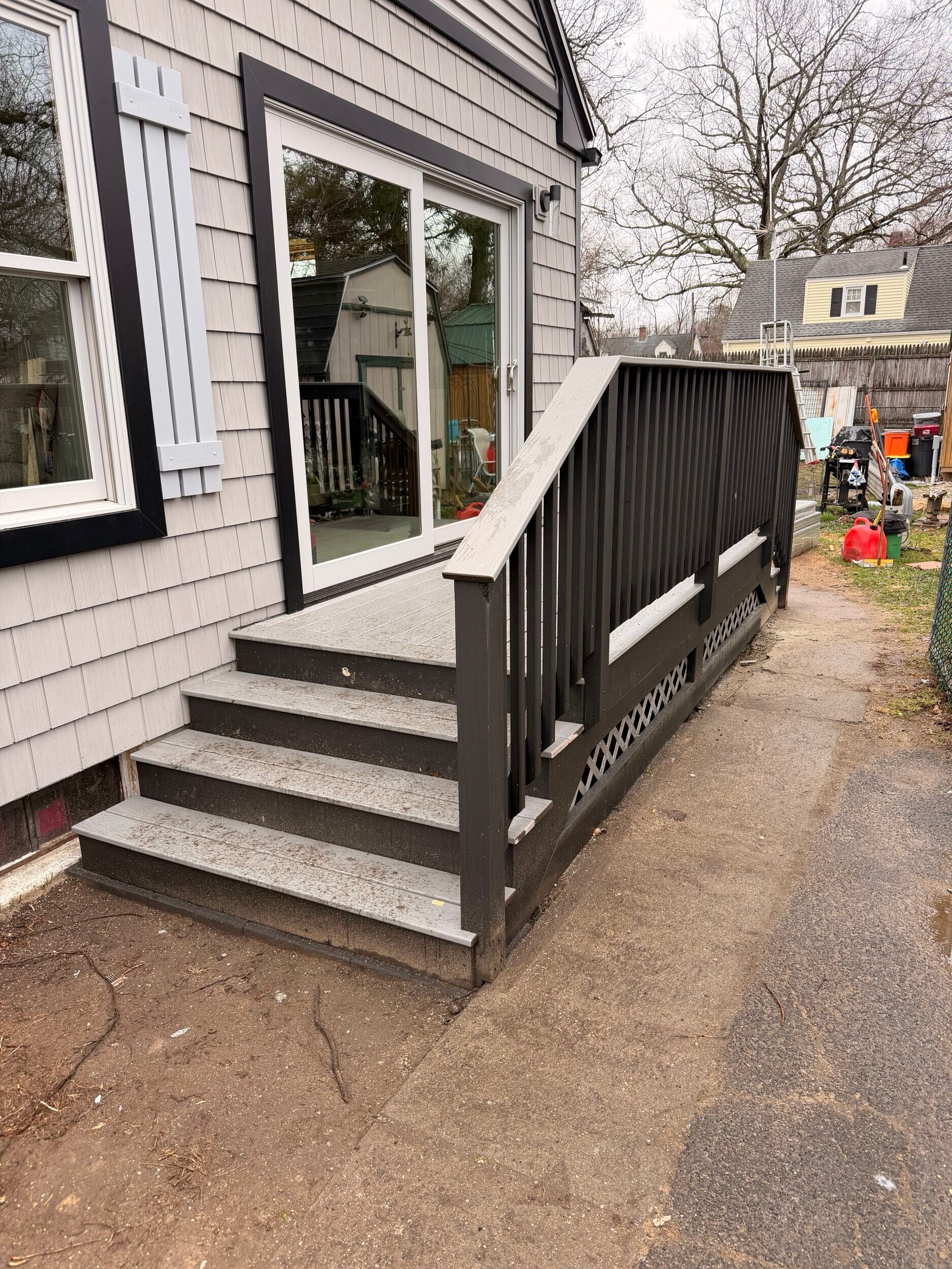 Front entrance with steps and an accessibility ramp beside a white building.