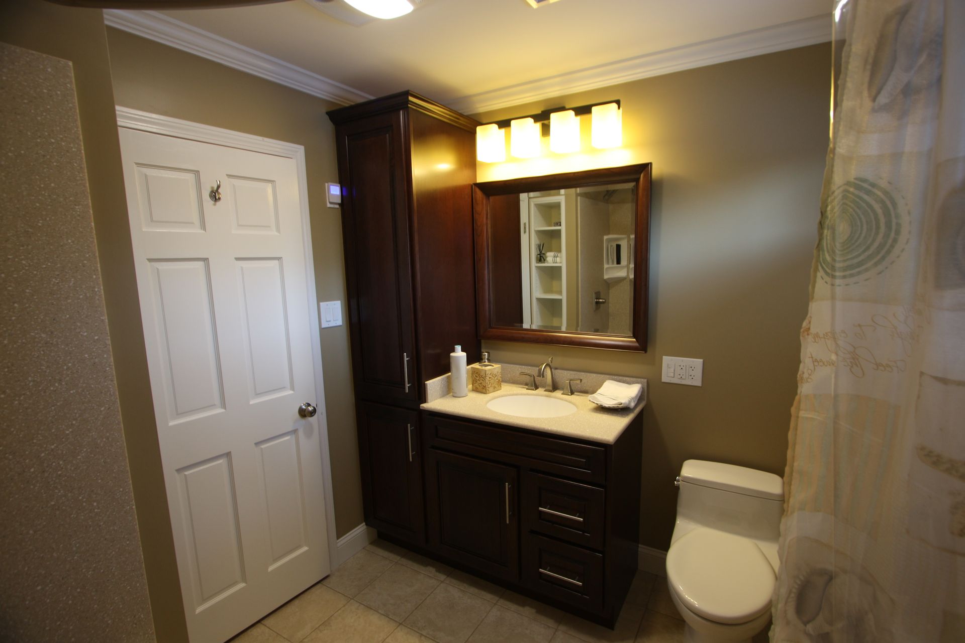 A bathroom with a toilet, sink, and mirror.