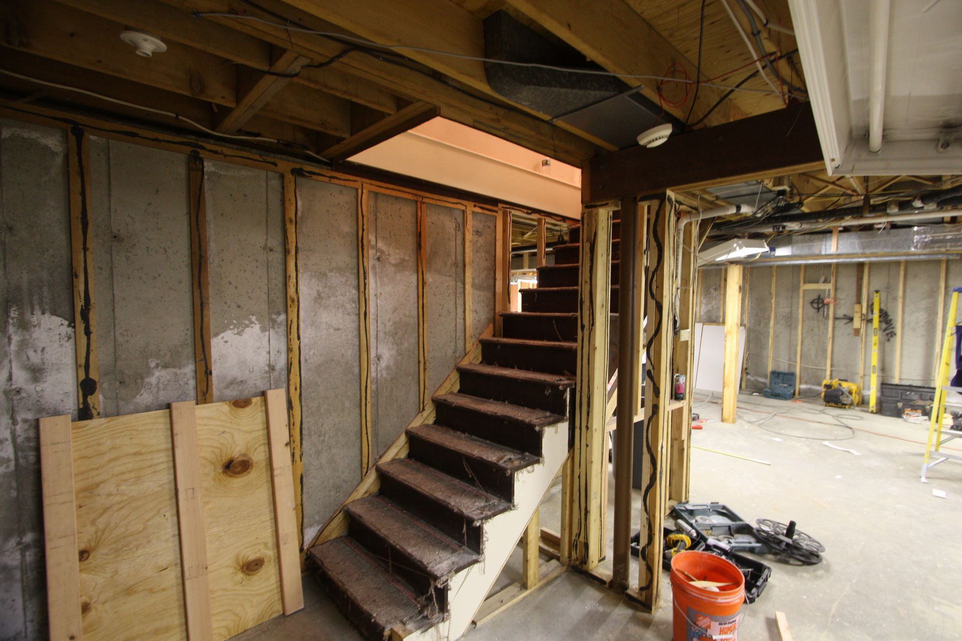 A staircase is being built in a basement under construction.