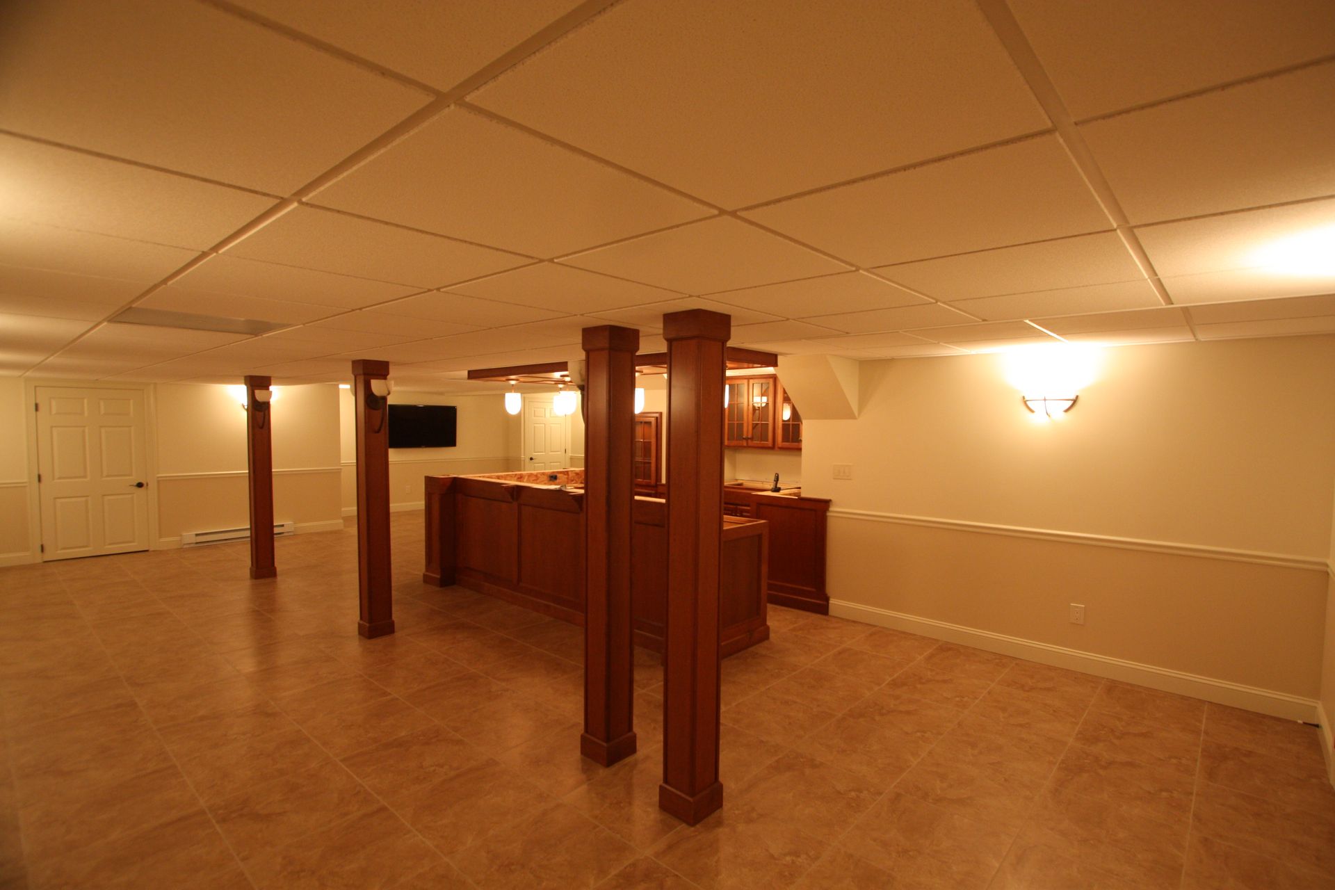 An empty basement with columns and a bar.