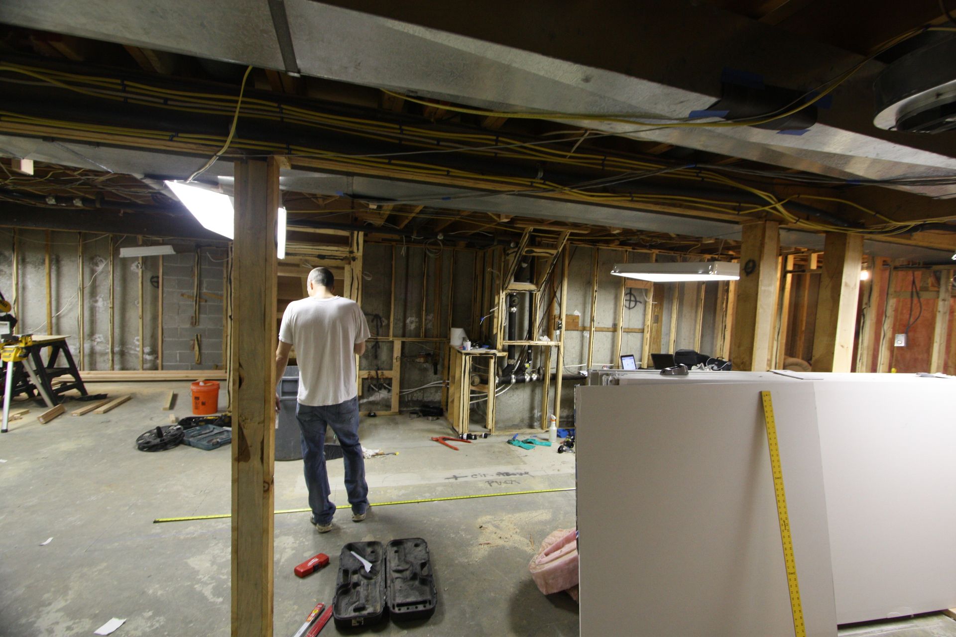 A man is standing in a basement under construction.