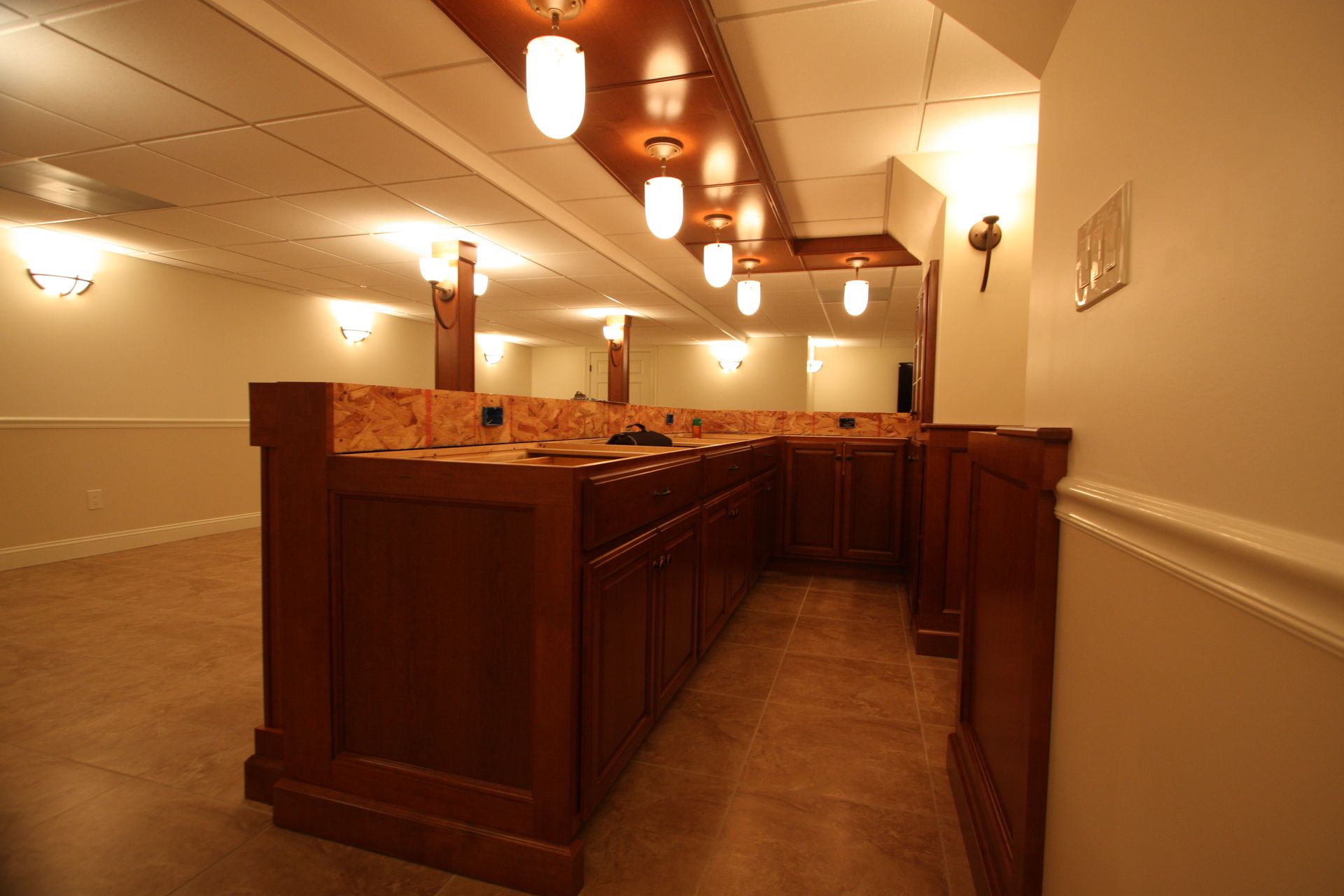 A very long hallway with a few lights on the ceiling.