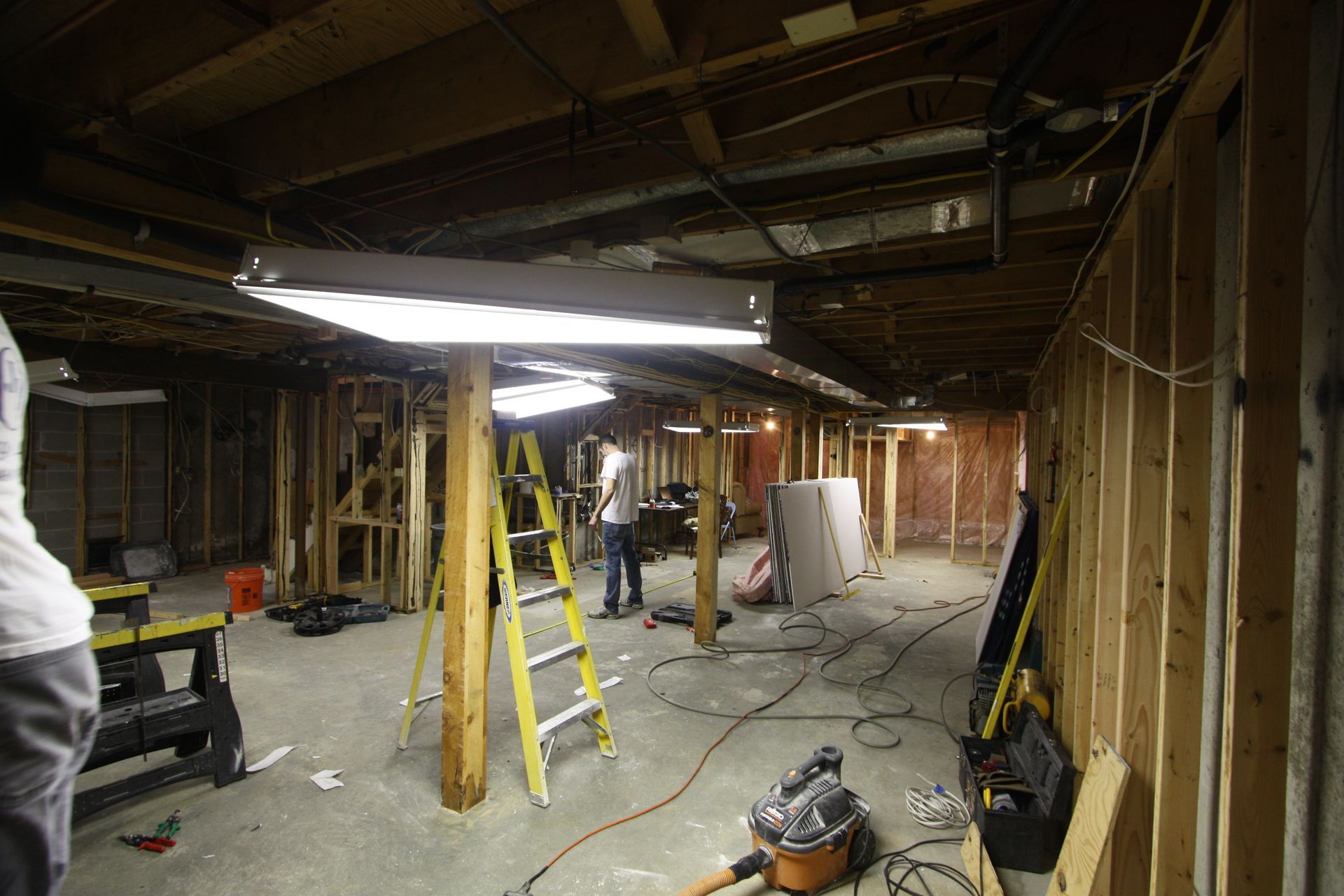 A man is standing in a basement under construction.