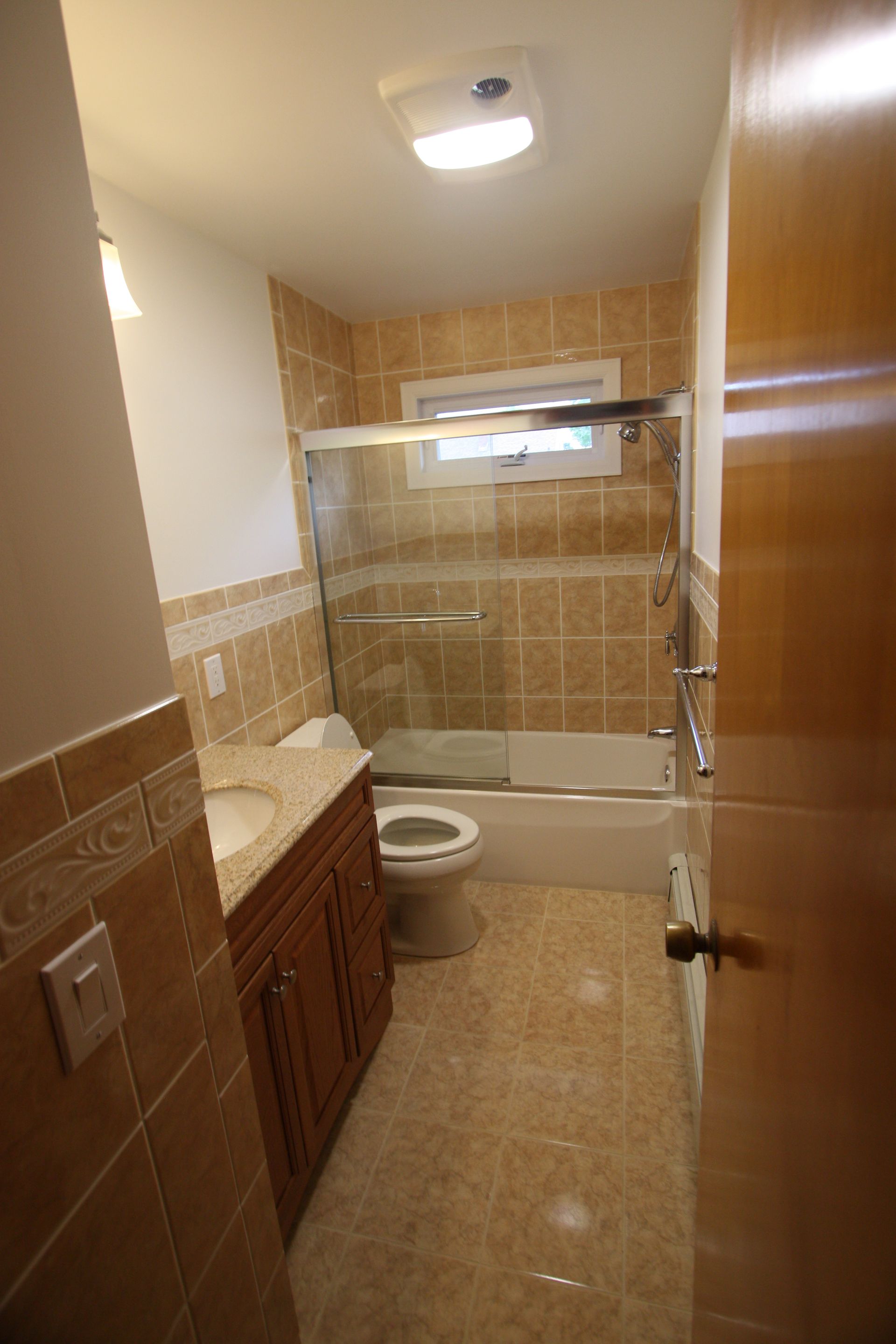 A bathroom with a toilet, sink, tub, and shower.