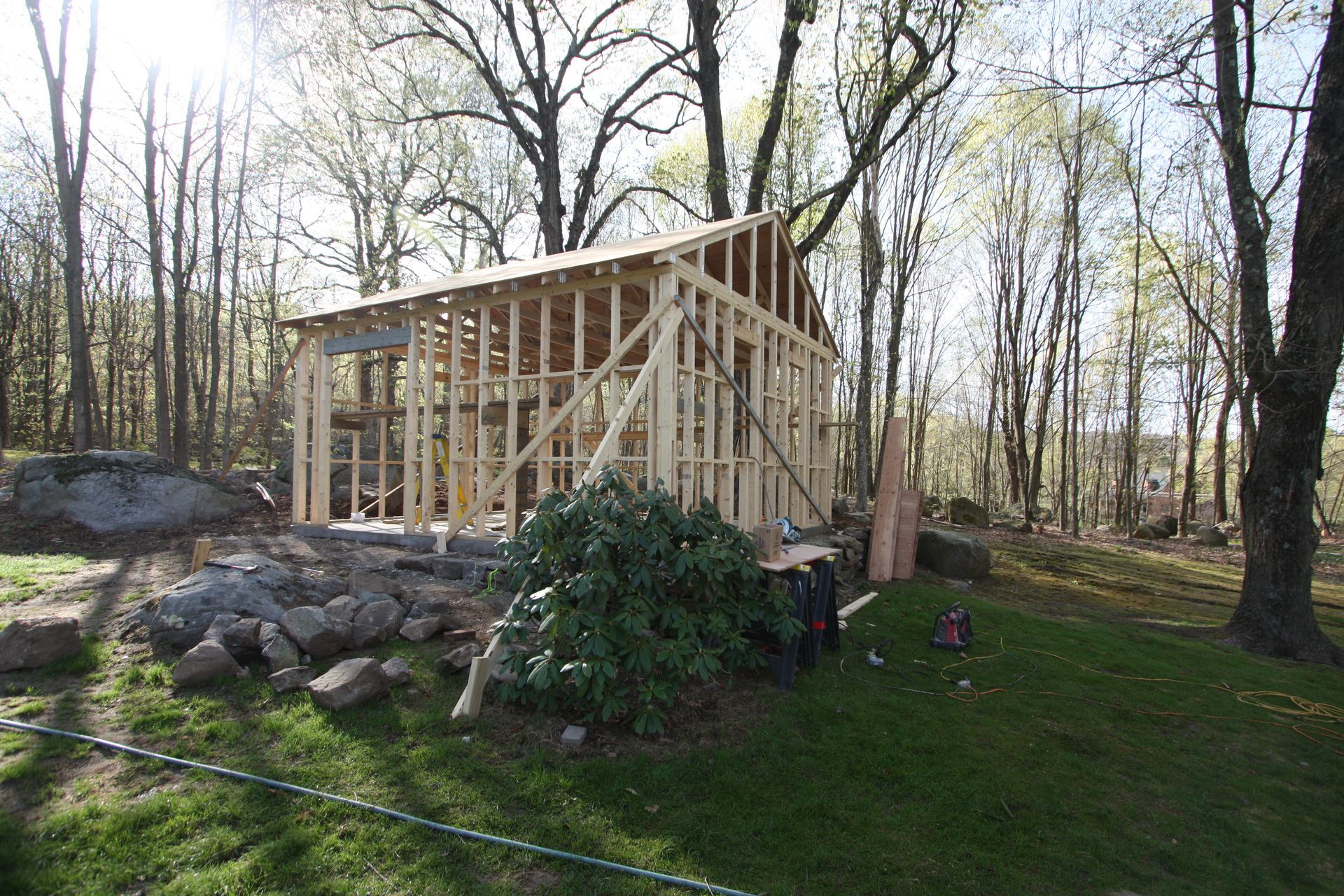 A wooden structure is being built in the middle of a forest.