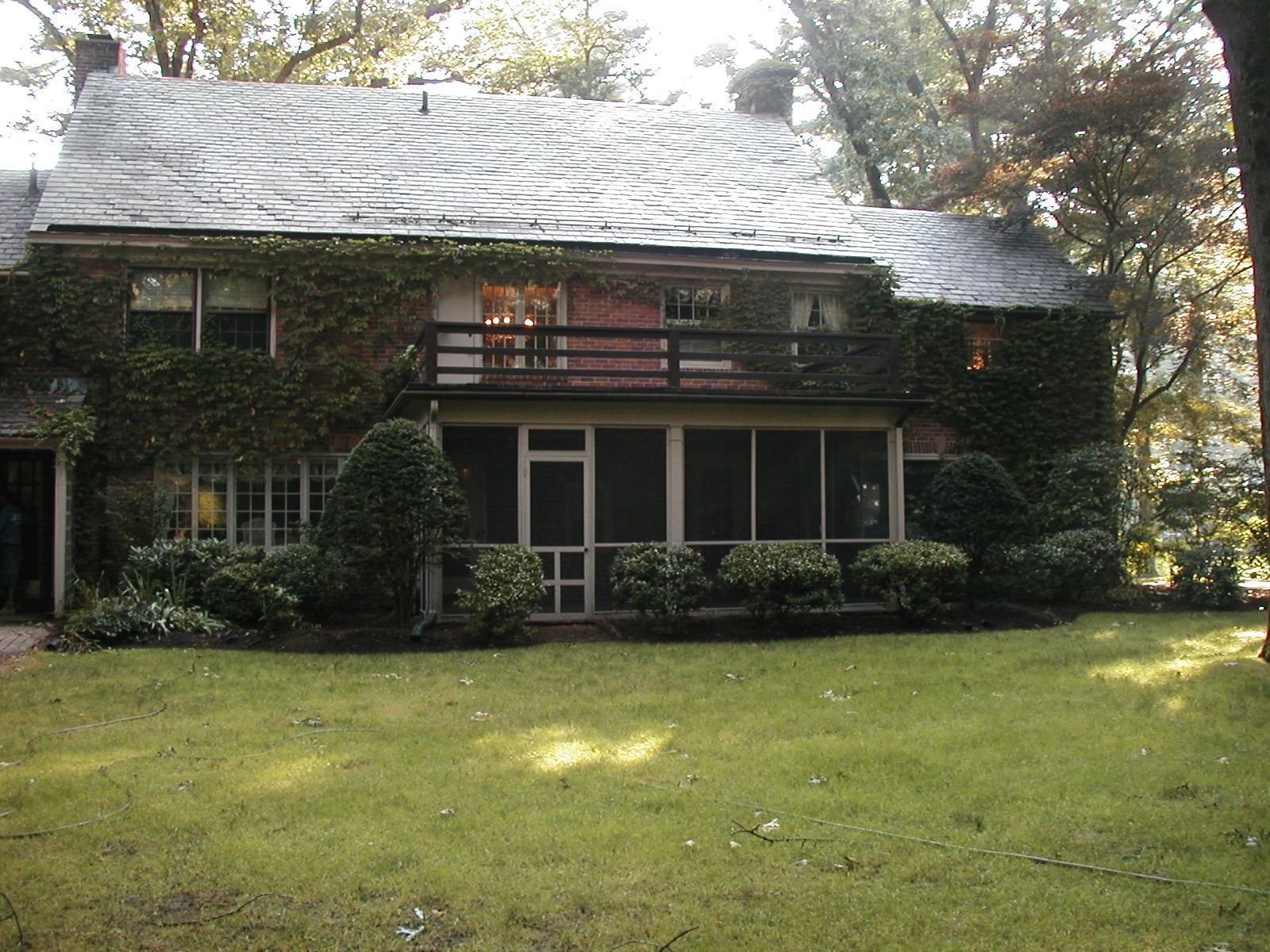 A house with a screened in porch and a balcony.