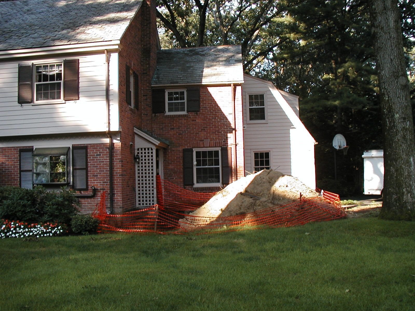 A large pile of dirt sits in front of a house.