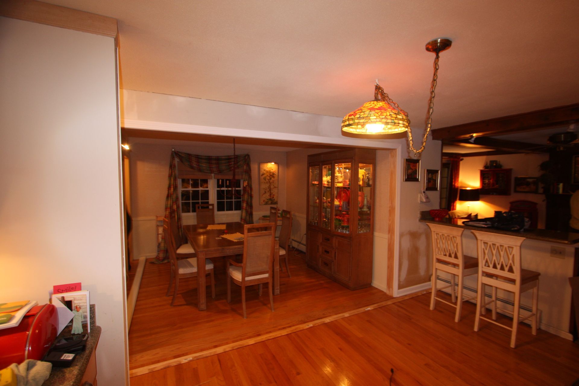 A living room with a dining room table and chairs and a bar.