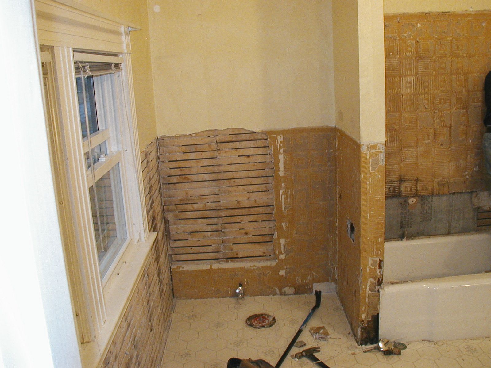 A bathroom with a bathtub and a window being remodeled.