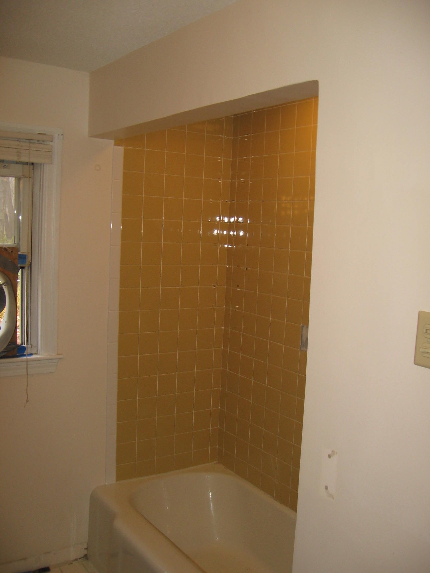 A bathroom with a bathtub and a window.
